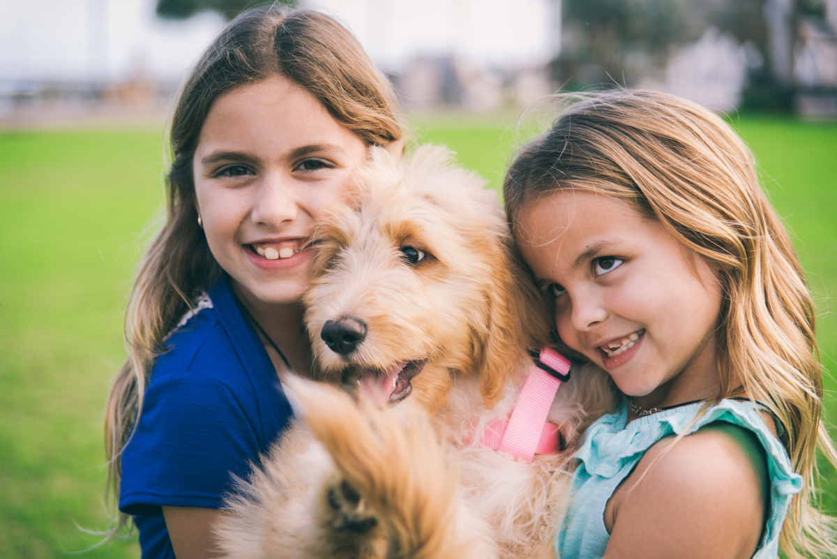 two girls hold a dog