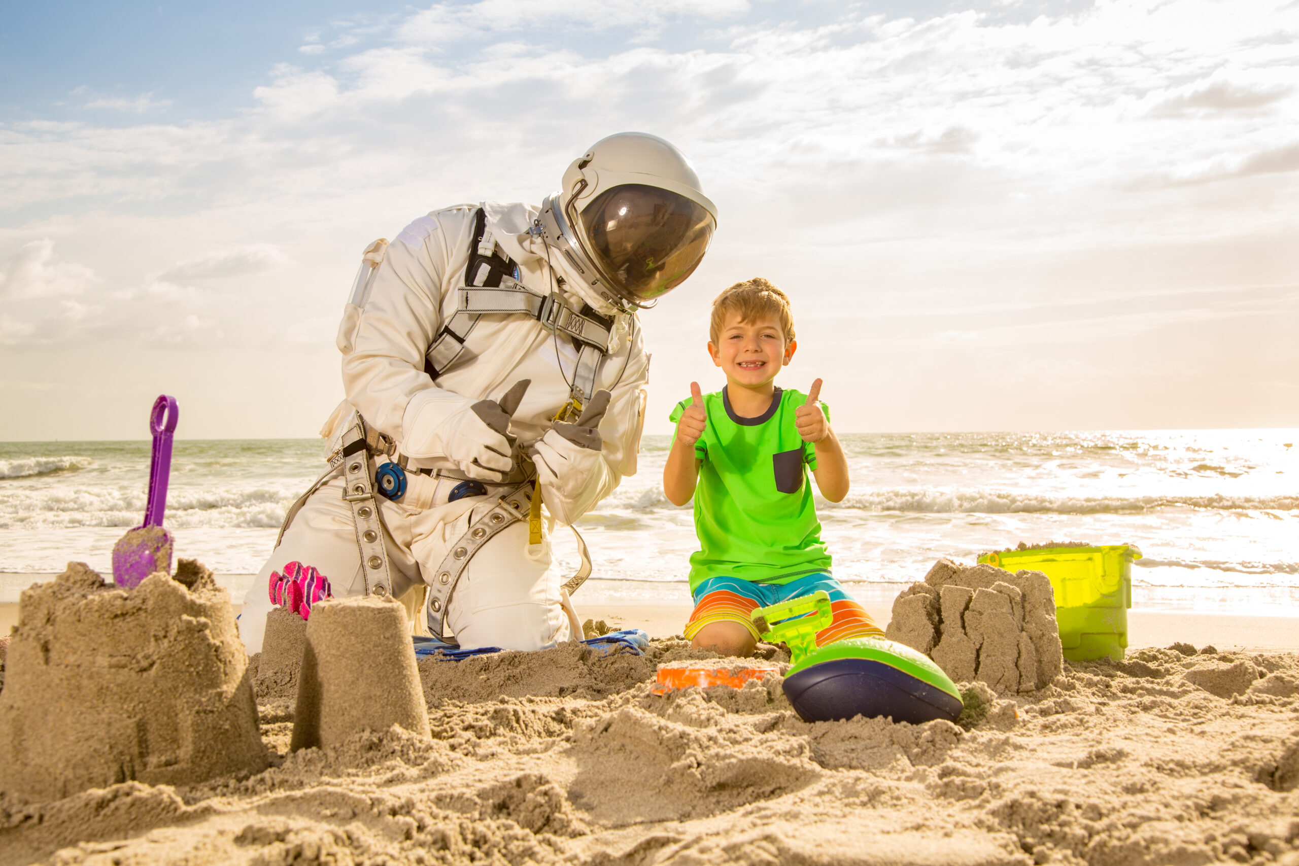 Starman and boy building sand castles on the beach