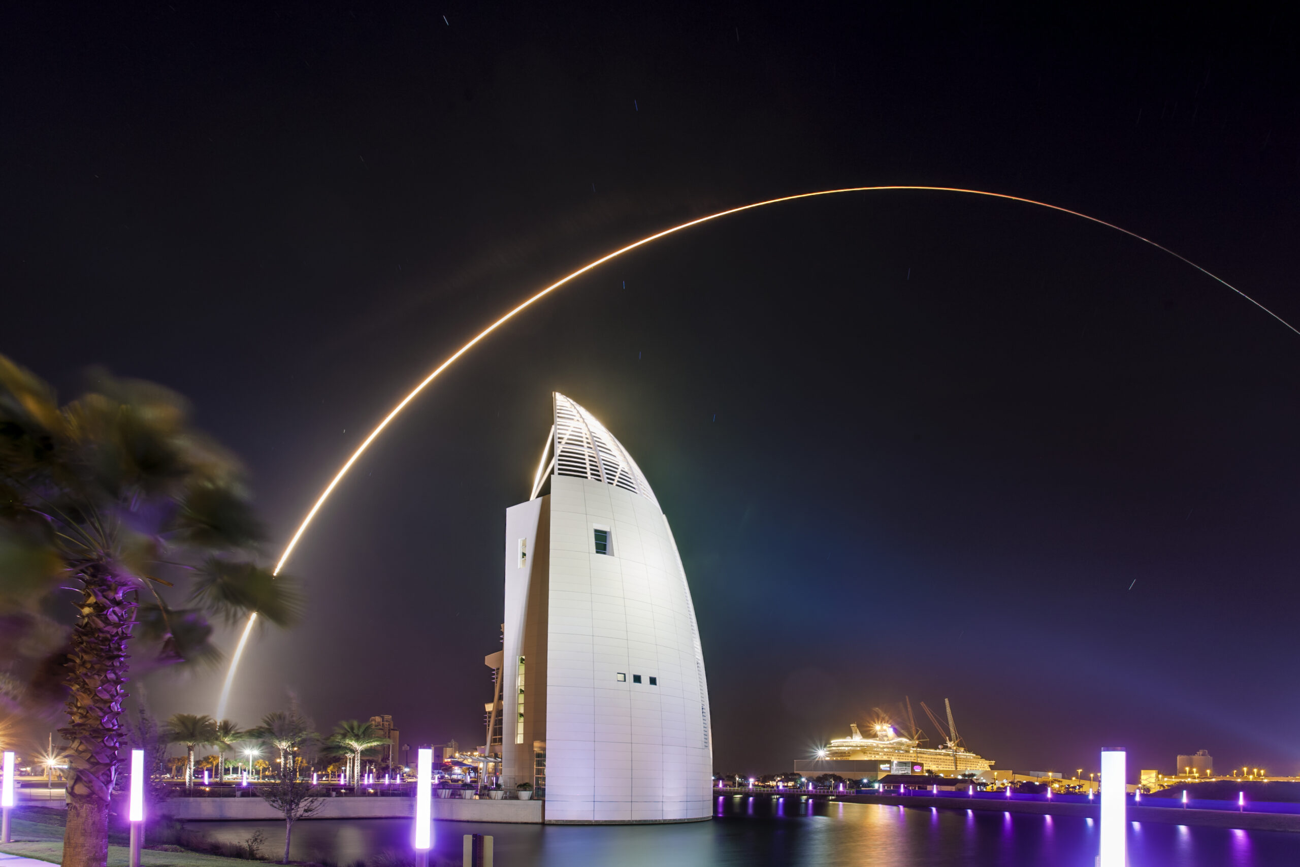A nighttime rocket launch seen flying above the Exploration Tower in Port Canaveral