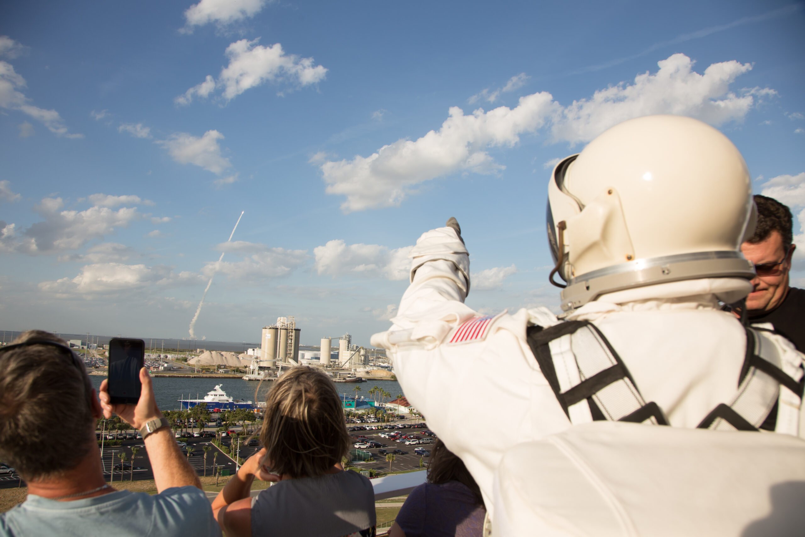 An astronaut watches a rocket launch from the viewing balcony at the Exploration Tower in Port Canaveral