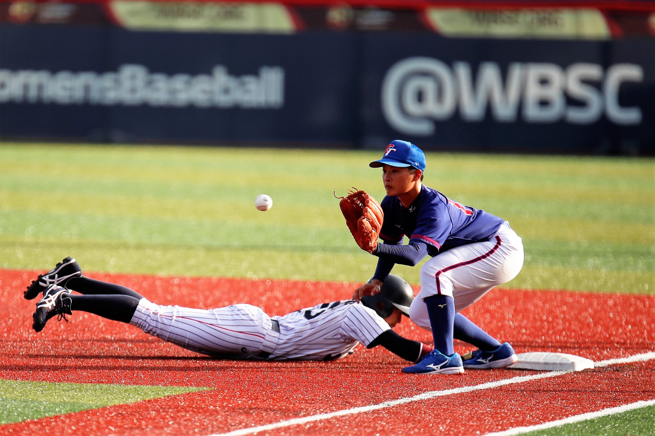 A player makes an out at first in the Women's Baseball World Cup at USSSA Space Coast Complex in Viera, FL