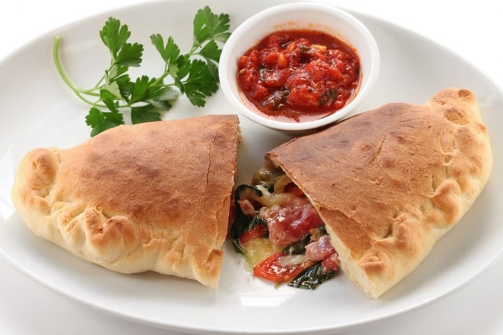 Wagon Wheel Pizza Calzone on plate with a side of sauce