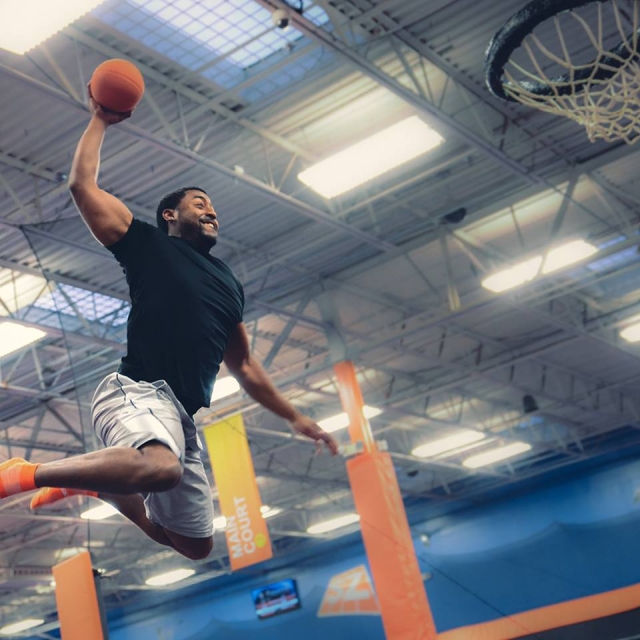 Sky Zone Indoor Trampoline Park Man Dunking a Basketball