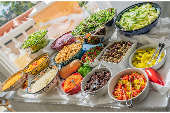 A Salad bar with various veggies and toppings