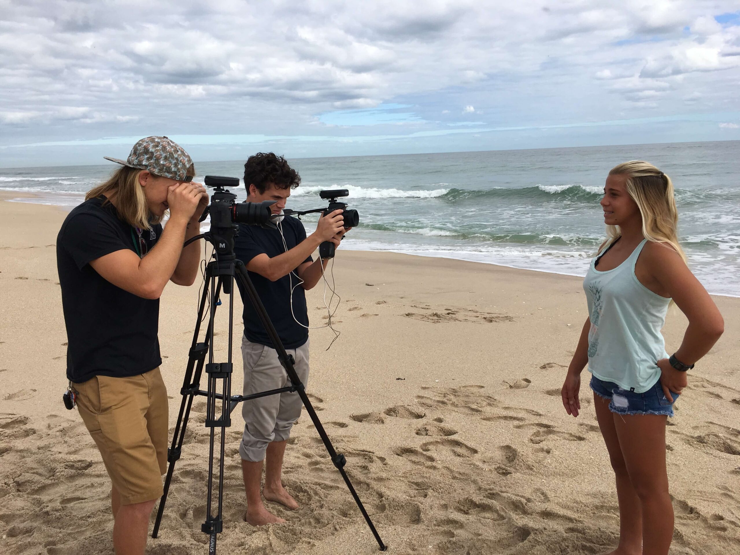 a crew records an interview on the beach