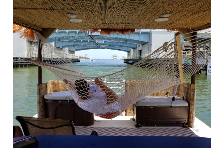 person relaxes on hammock aboard the "Liki Tiki"