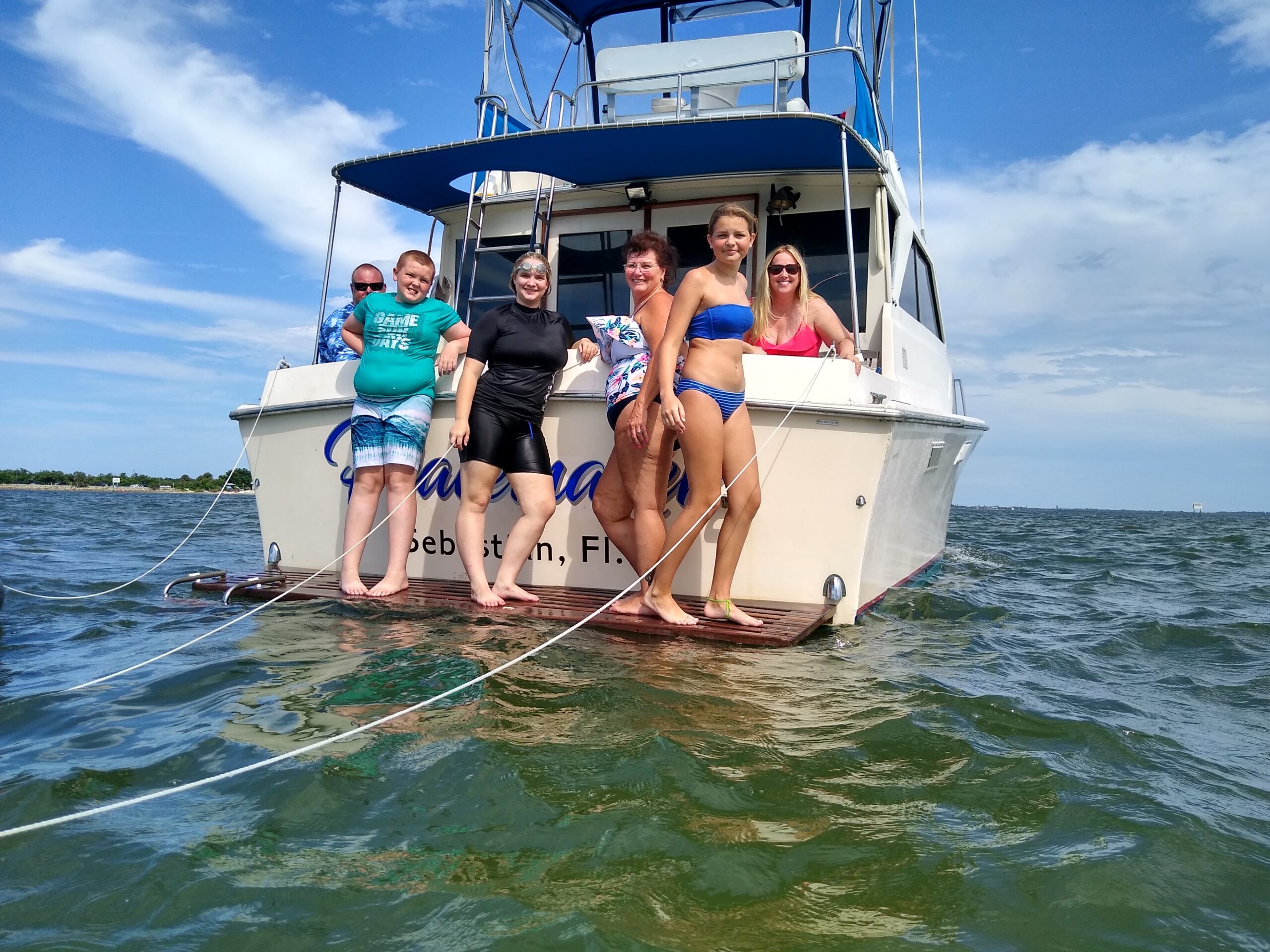 A family hangs out on the back of a fishing charter boat